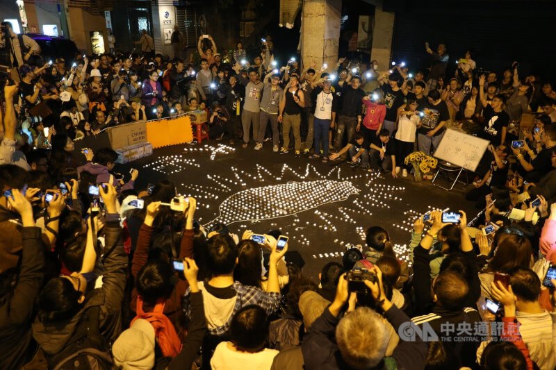 4月9日,許多民眾在鎮江街口將蠟燭排成台灣形狀,高唱「島嶼天光」。(中央社檔案照片)