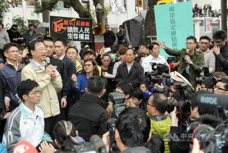 「反黑箱服貿民主陣線」等學生成員占據立法院議場表達抗爭,群眾排隊讓出一條通道,鼓掌讓準備上哨的警員進入立法院交班。(中央社檔案照片)