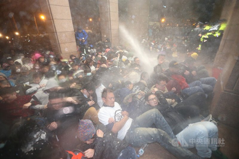 反服貿民眾衝入行政院占據廣場與部分建築,凌晨4時30分,警方以水柱驅離民眾。(中央社檔案照片)