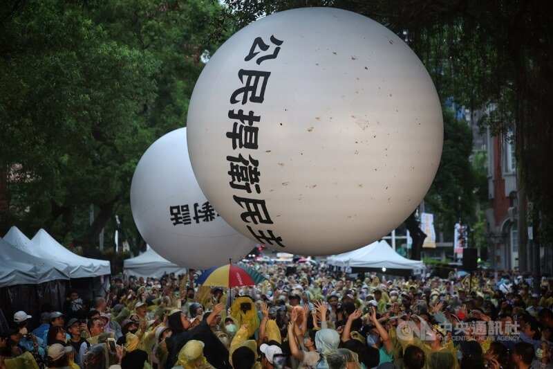 立法院會三讀修正通過立法院職權行使法部分條文,場外抗議民眾接力將2顆寫有「公民捍衛民主」、「重啟社會對話」的白色大球推向立法院。中央社記者王飛華攝 113年5月28日