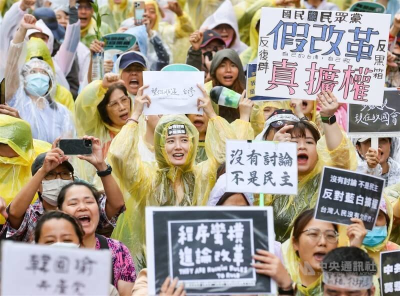 立法院會28日三讀修正通過立法院職權行使法部分條文,法案三讀時,立院外飄下陣雨,抗議民眾穿上雨衣不畏雨勢,舉起標語並高喊口號表達不滿。中央社記者鄭清元攝 113年5月28日