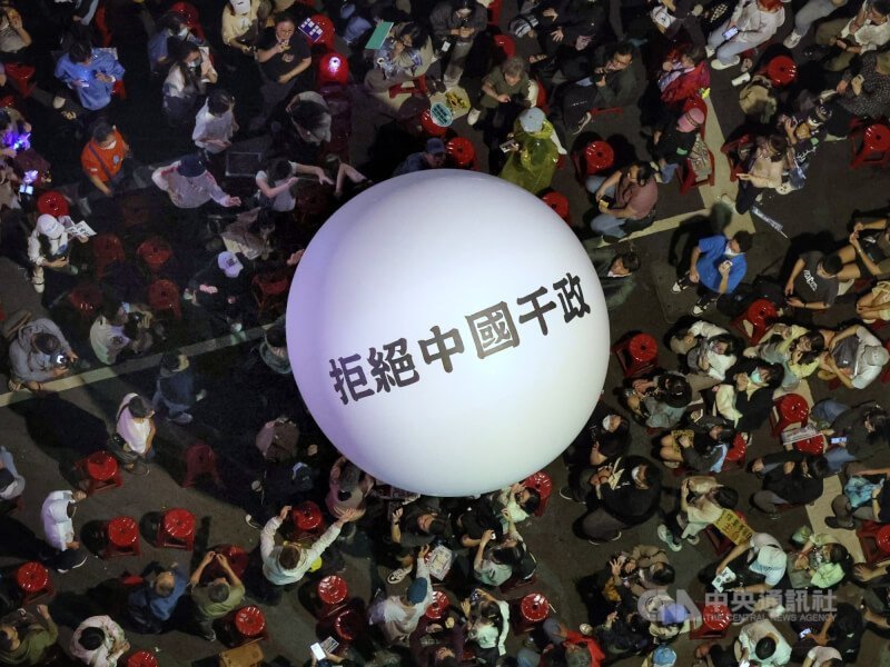 「青鳥行動」參與者滾動寫有「拒絕中國干政」的白色大球。中央社記者王飛華攝 113年5月28日