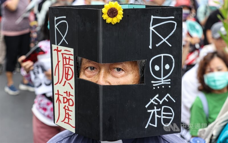 民眾頭戴寫有「反黑箱、反擴權」標語的紙箱表達訴求。中央社記者鄭清元攝 113年5月28日