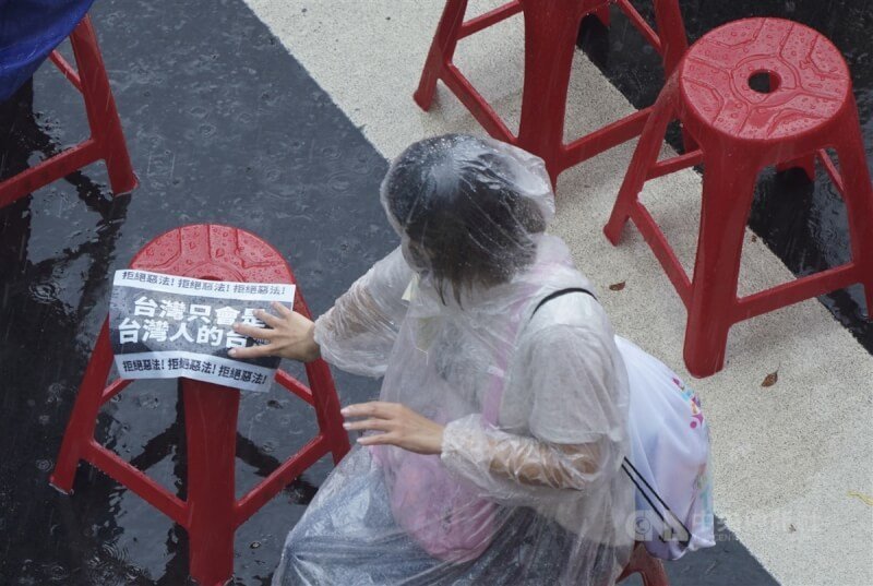 對流雲系發展旺盛，中央氣象署21日下午發布台北市、新北市等10縣市大雨特報。圖為立法院外參與「青鳥行動」的民眾在雨中拿標語表示立場。中央社記者徐肇昌攝 113年6月21日