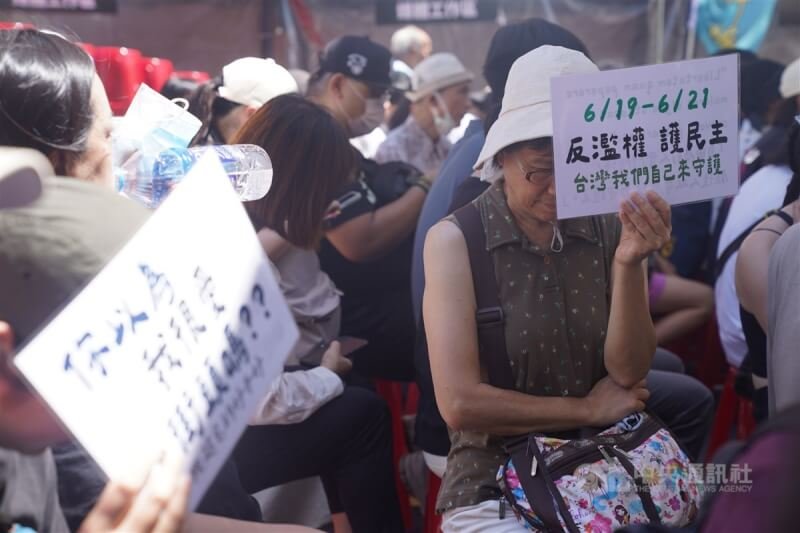 立法院21日表決行政院對國會職權修法所提覆議案，場外「青鳥行動」再起。圖為覆議案開票後，民眾仍手持標語表達立場。中央社記者張新偉攝　113年6月21日