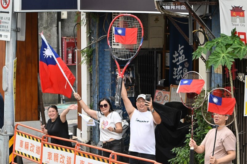 民眾發揮創意自製道具迎接奧運選手。(台北市攝影記者聯誼會提供)