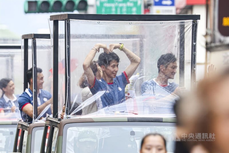 勇奪拳擊奧運隊史首金的林郁婷(車上左)比出愛心,向支持者表達感謝。中央社記者鄭清元攝 113年8月16日