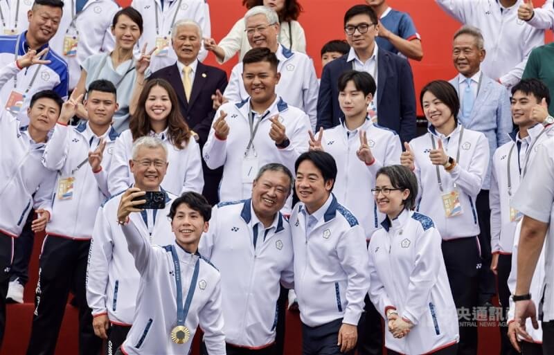 「Our Heroes!Team Taiwan 台灣英雄 榮耀同行」活動16日登場,下午在總統府舉辦英雄派對,勇奪巴黎奧運女子拳擊57公斤級金牌的台灣好手林郁婷(前左)拿起手機與總統賴清德(前右2)、副總統蕭美琴(前右1)、中華奧會主席林鴻道(前右3)及選手們自拍。中央社記者裴禛攝 113年8月16日