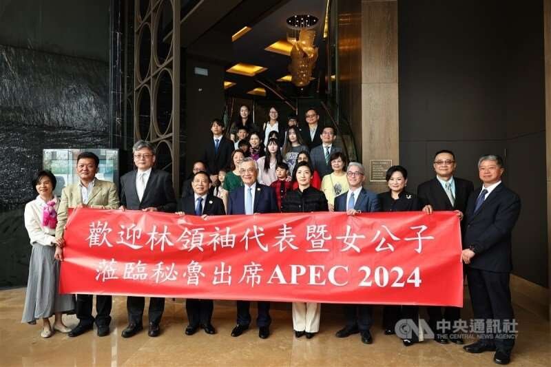 APEC台灣領袖代表、總統府資政林信義(前左5)赴秘魯利馬參加APEC經濟領袖會議,林信義與女兒林玟萱(前右5)一同在當地時間13日中午抵達下榻酒店,並與僑胞拿著紅布條合影。 中央社記者翁睿坤利馬攝 113年11月13日