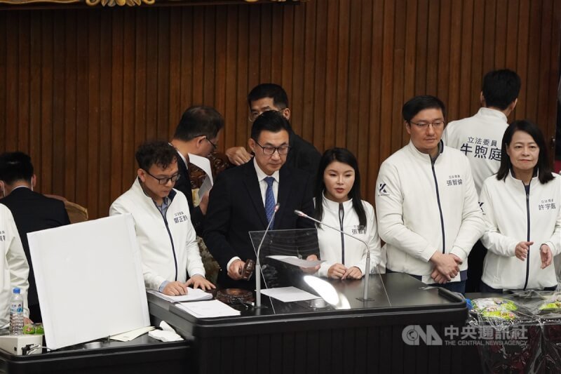 立法院會20日在衝突中以舉手表決三讀修正通過選罷法部分條文,立法院副院長江啟臣(前左2)在多名國民黨籍立委包圍陪伴下,正式敲槌宣布選罷法三讀。中央社記者徐肇昌攝 113年12月20日
