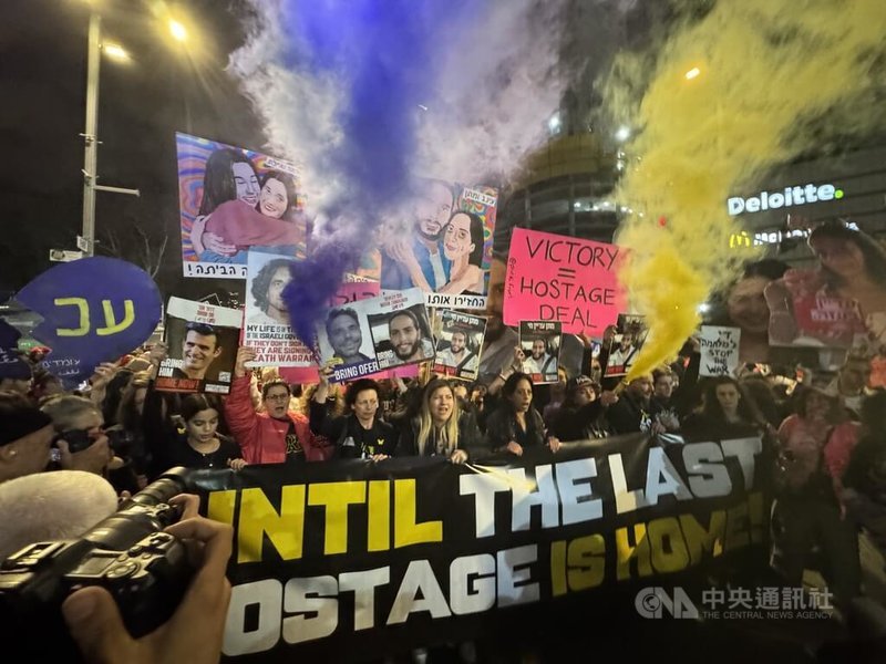 以色列國防部大門前,停火與人質協議中未列入第一階段釋放名單的人質家屬高舉失蹤者的照片,燃放煙火、火把,鼓聲和口號聲此起彼落,氣氛激昂。中央社記者賴素芬特拉維夫攝 114年1月19日