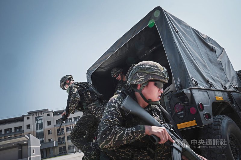 防空群戒護營的一年期義務役官兵,在接獲任務指令後前往戰術位置,並自悍馬車上躍下。中央社記者游凱翔攝 114年4月4日